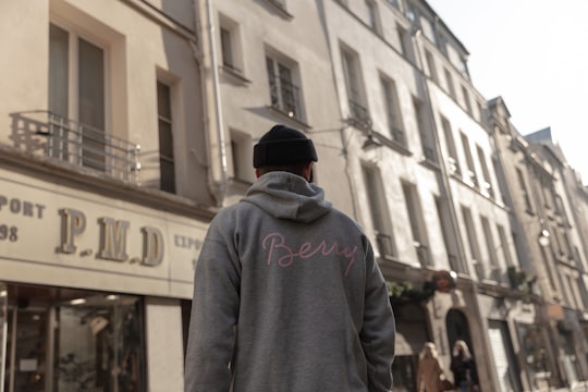 man wearing gray pullover walking on street in Rue du Temple France