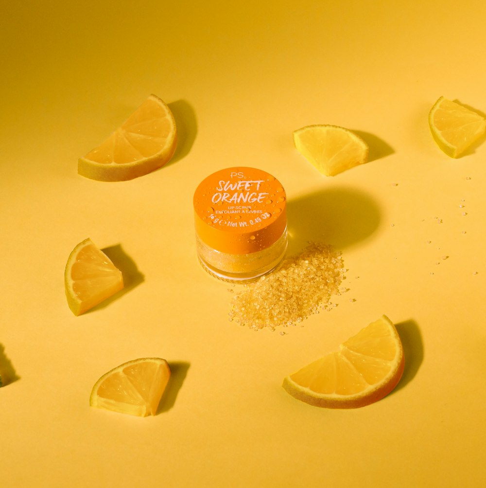 a jar of lip scrub surrounded by lemon slices