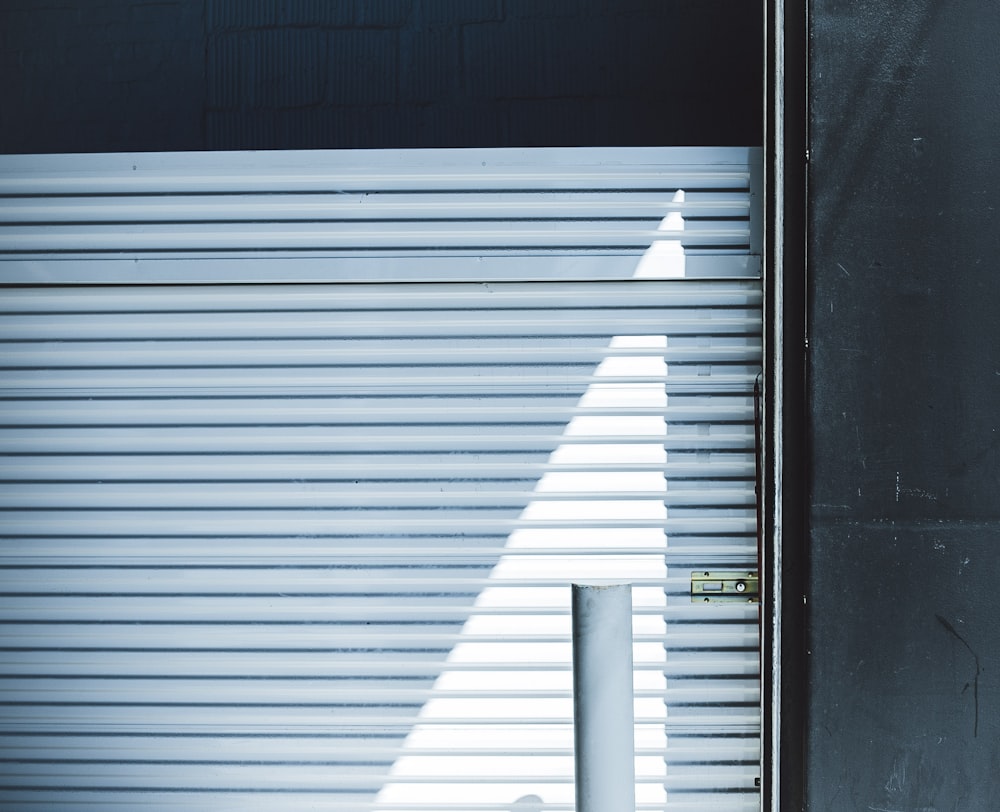 a tall white pole in front of a closed garage door
