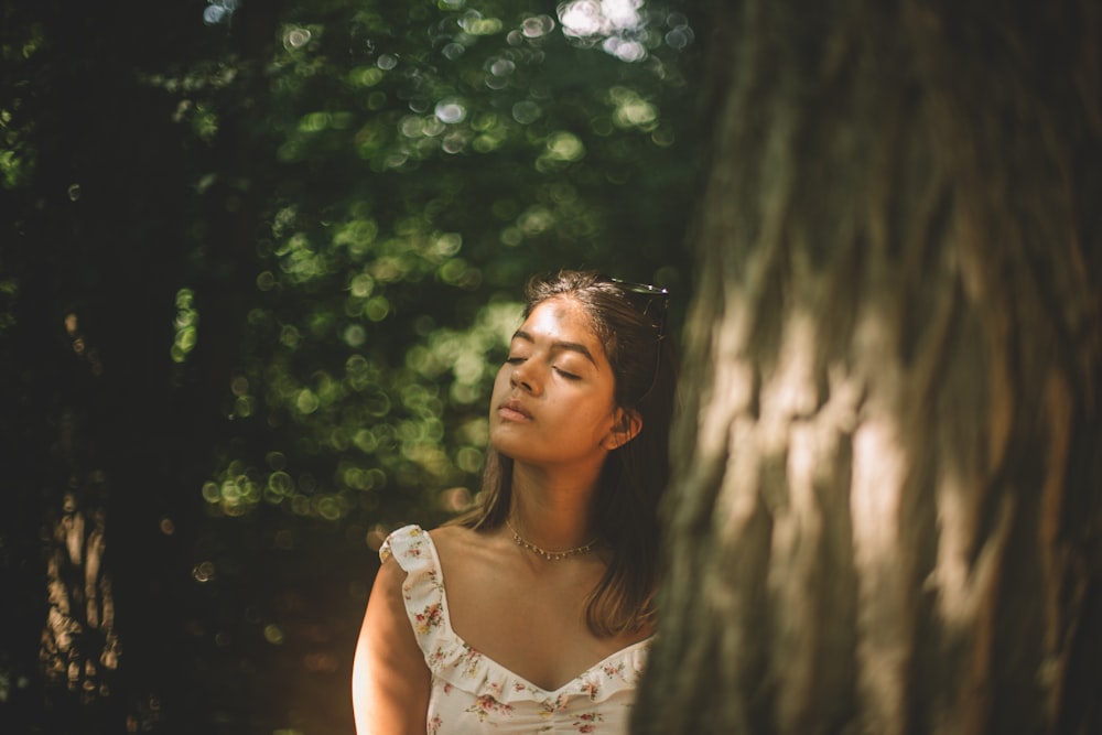 woman in white square-neck top standing in forest during daytime