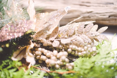 Close-up of a floral arrangement blending deep green foliage with shimmering gold accents.
