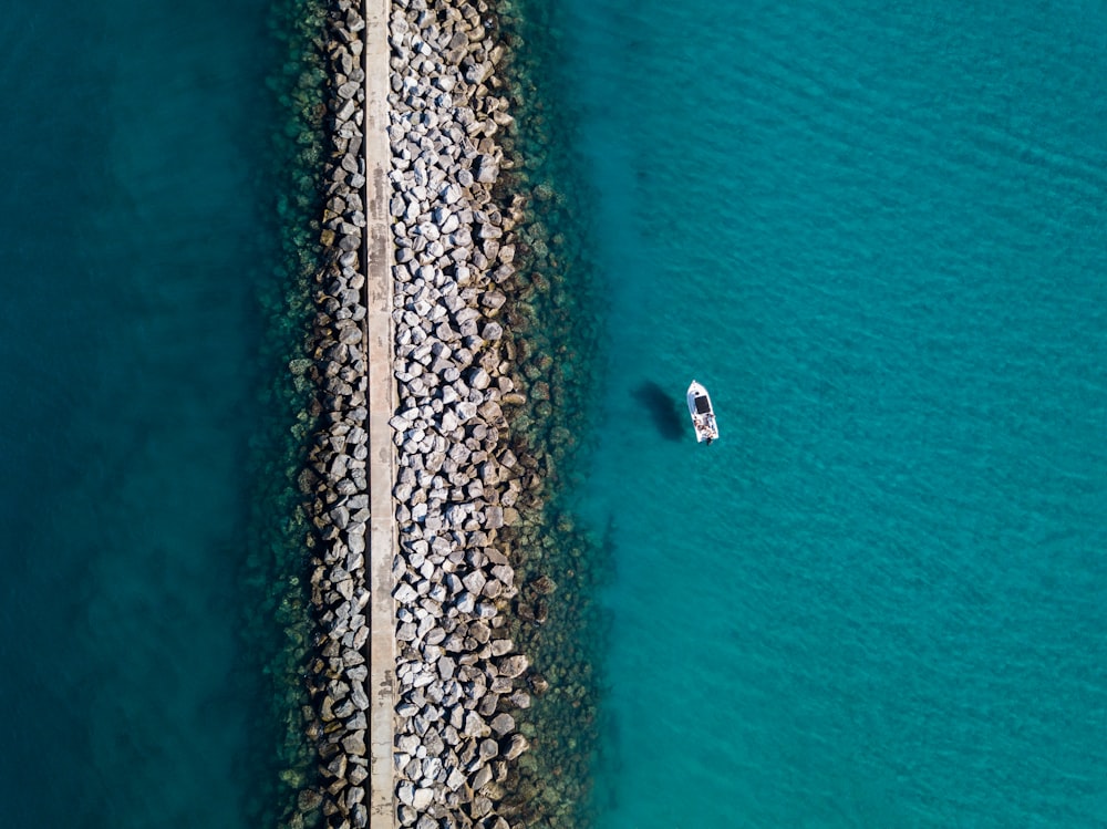 aerial photography of white boat near stone shore during daytime