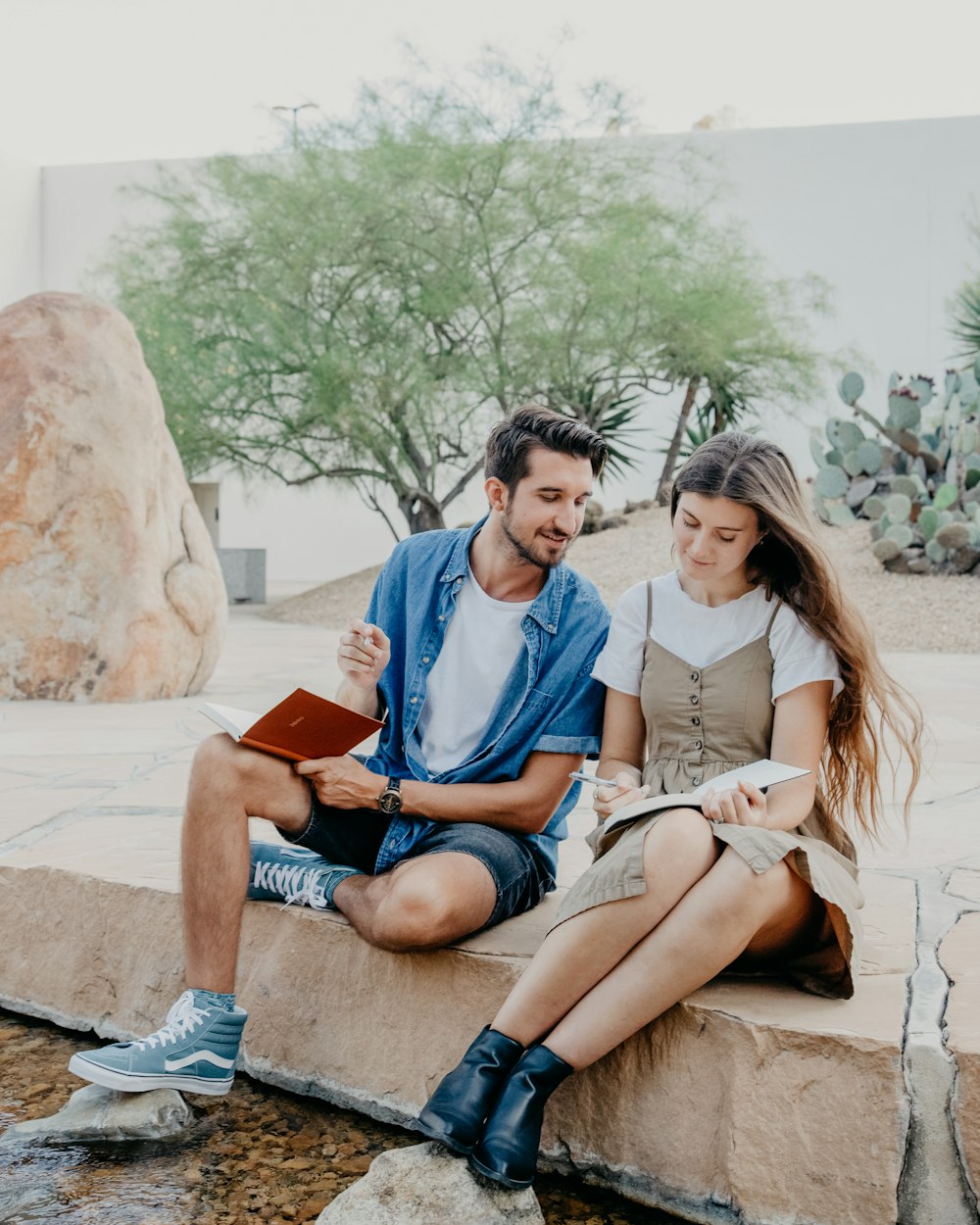 man and woman sitting on concrete panel