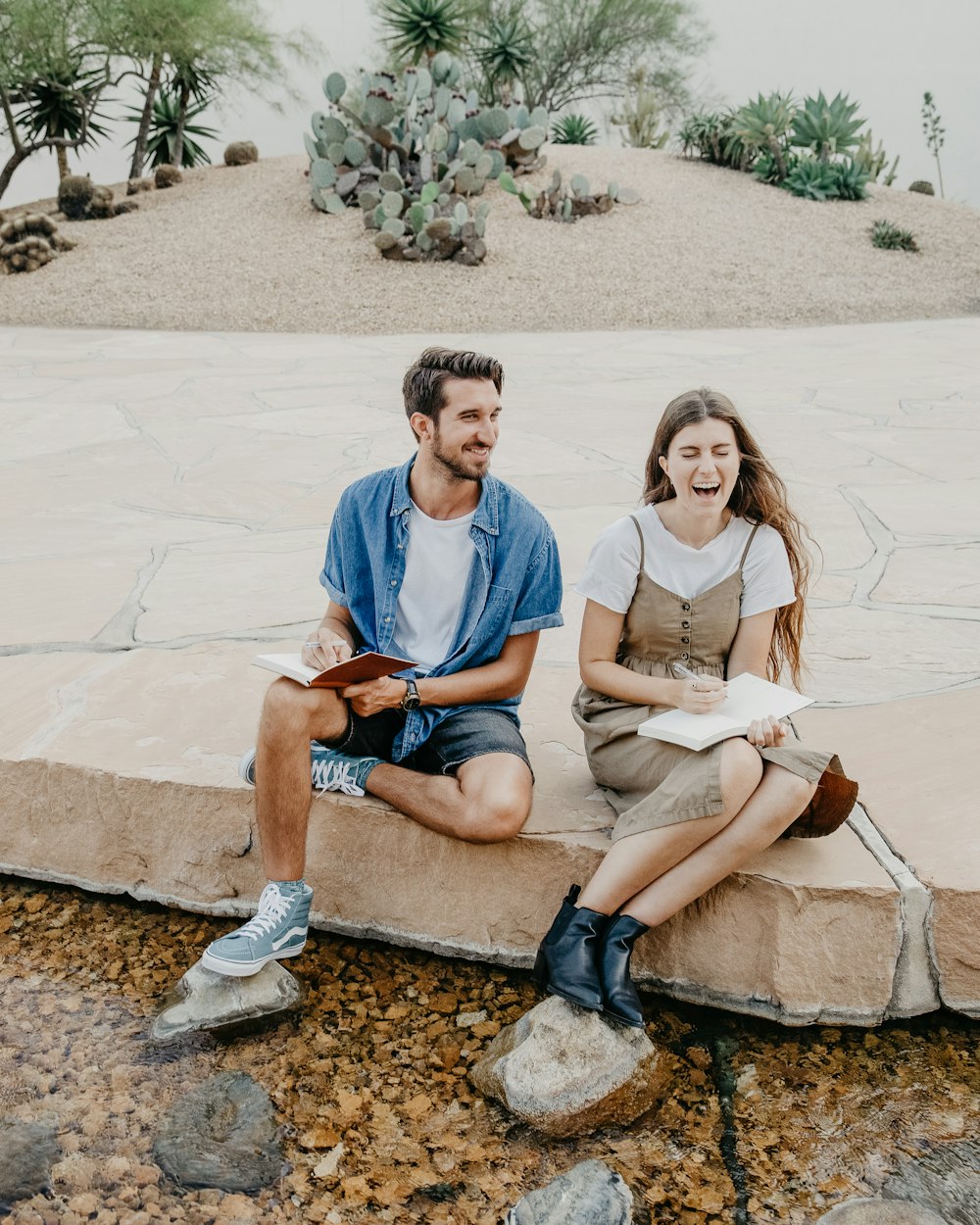 man and woman sitting side by side holding notebooks