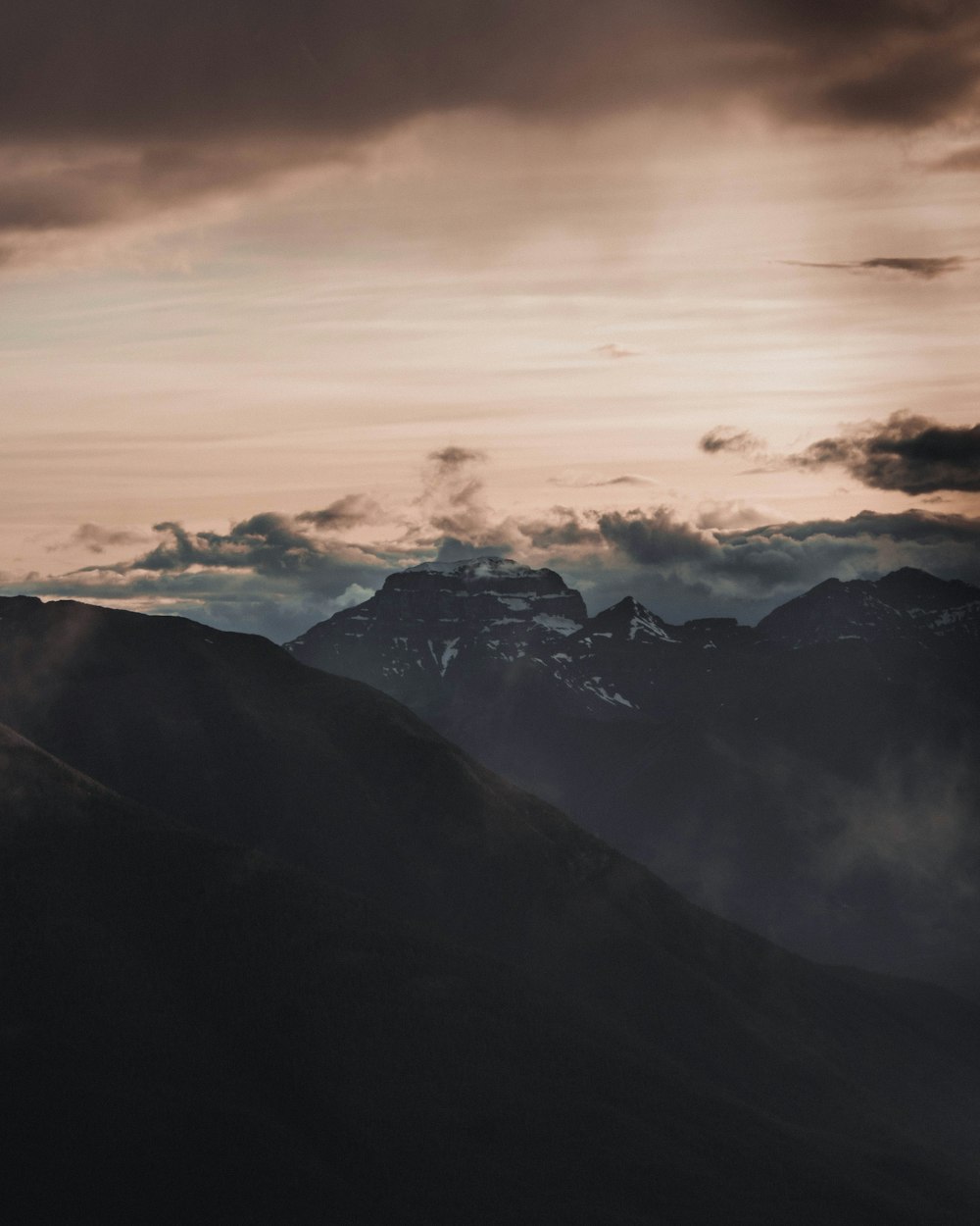 a view of a mountain range with clouds in the sky