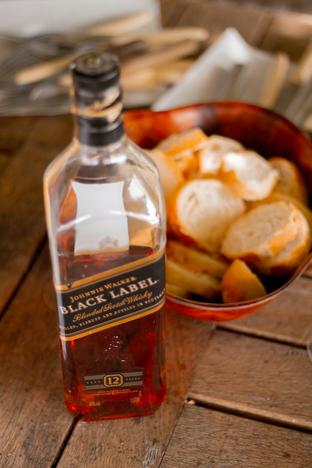 Johnnie Walker Black Label whisky bottle near sliced bread in bowl