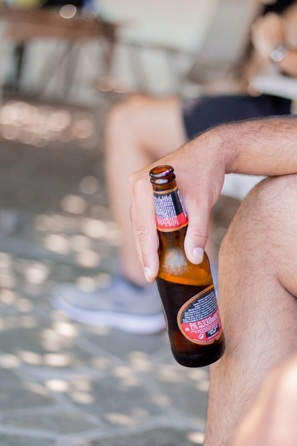 person holding blue and red labeled beer