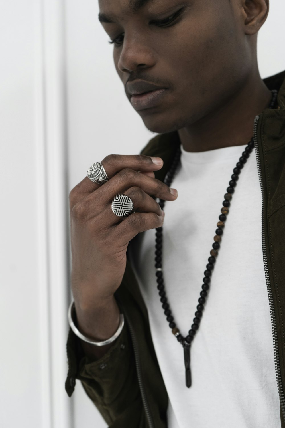 a man wearing a necklace and a ring