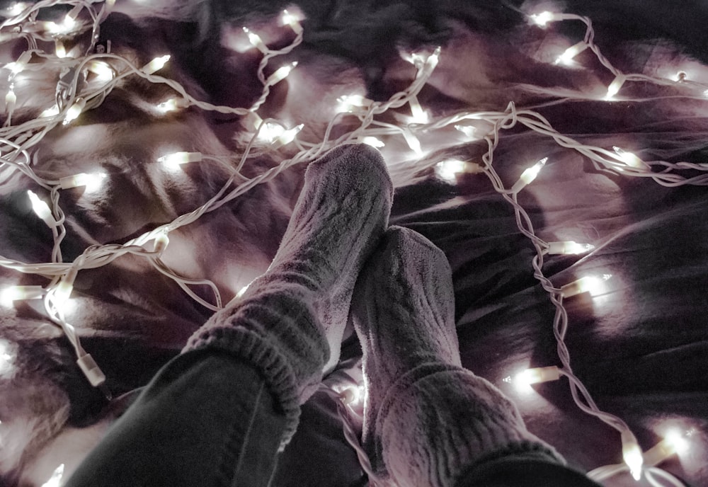 person wearing gray socks near white string lights