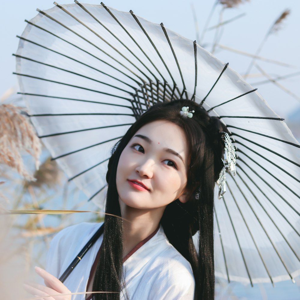 smiling woman using white umbrella