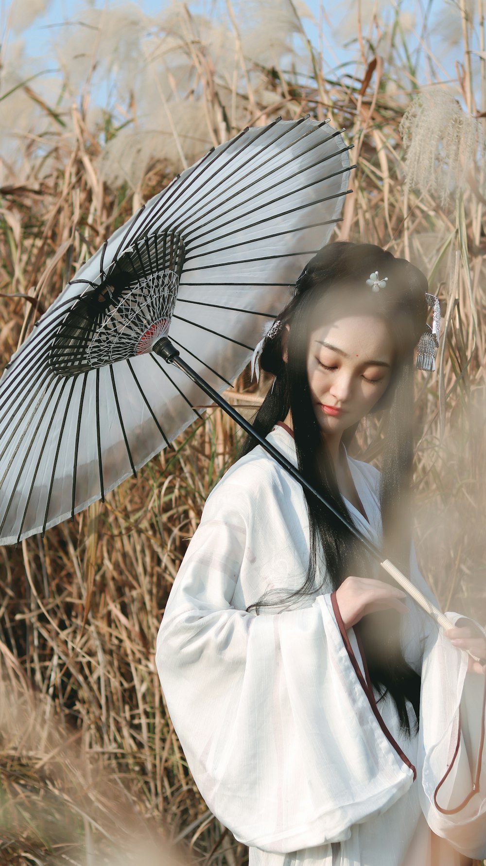 woman wearing white dress holding black umbrella