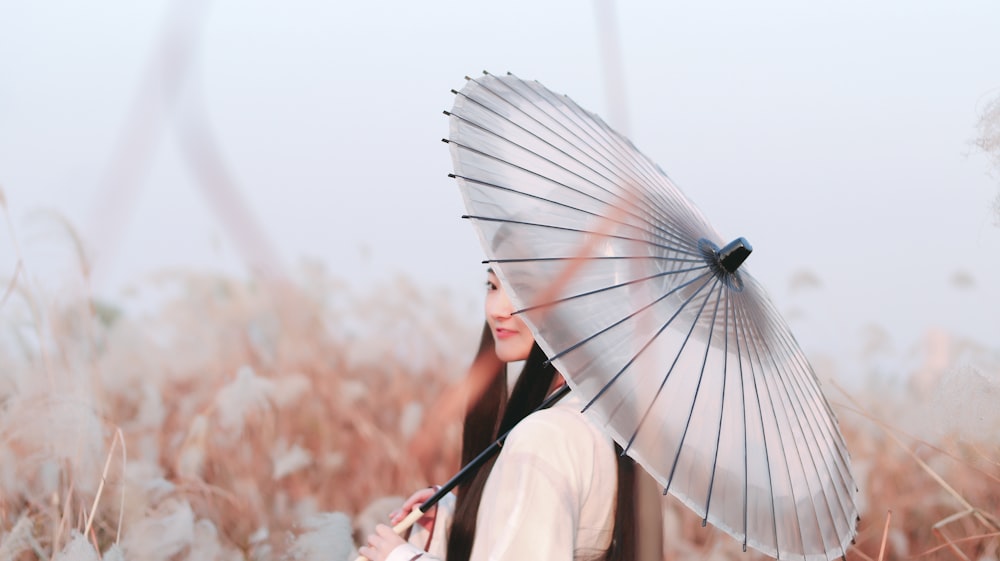 smiling woman using umbrella while standing