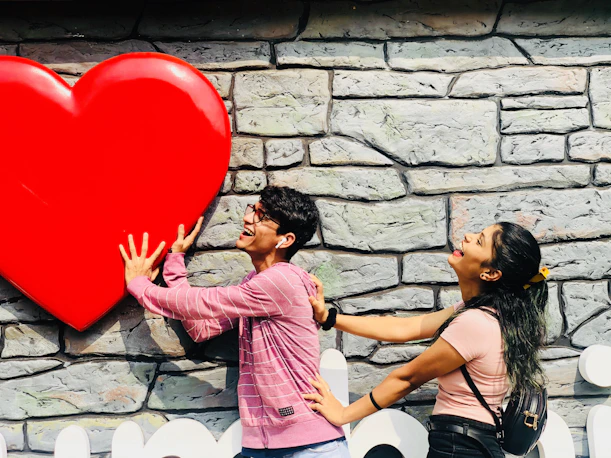 man and woman standing near heart cutout hang on wall