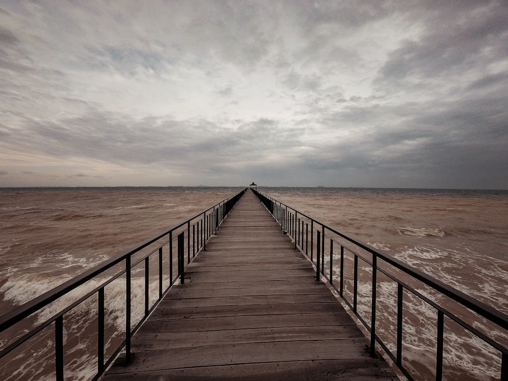 brown footbridge through the sea