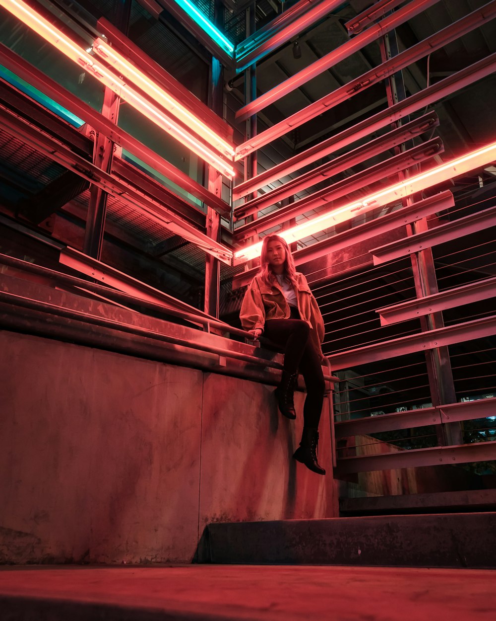 view photography of woman sitting on bench near building