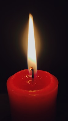 A scarlet candle set with subtle heart designs glowing warmly.