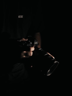 person holding black DSLR camera