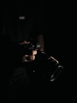 person holding black DSLR camera