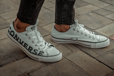 person wearing white converse low-tops footwear teams background