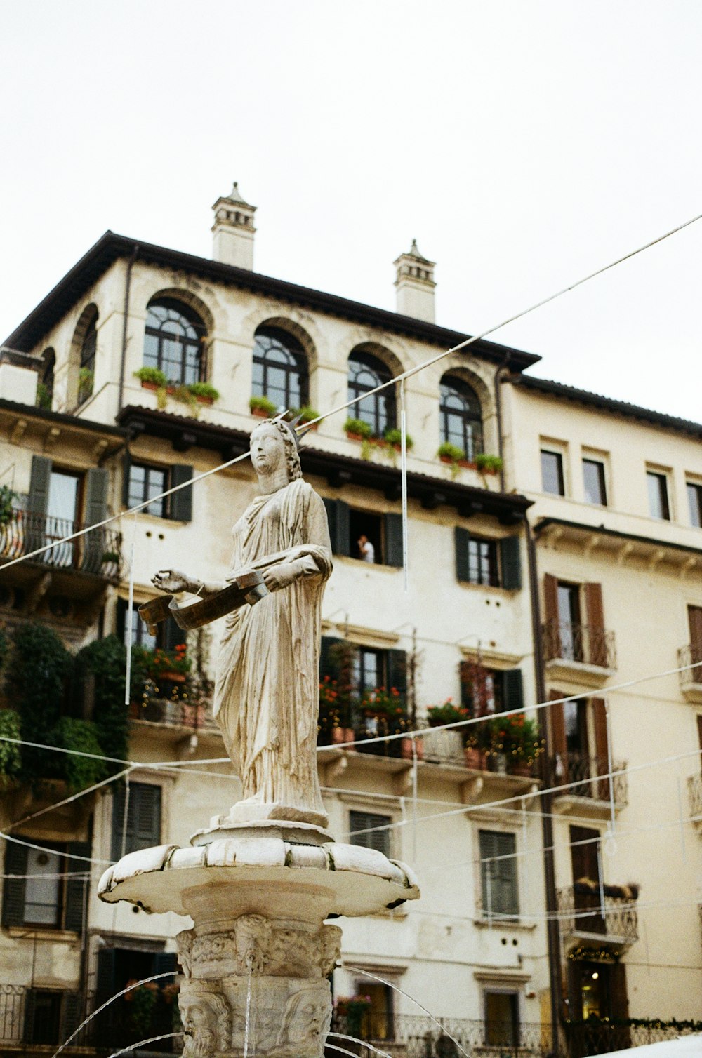 low-angle photography of white concrete statue and building