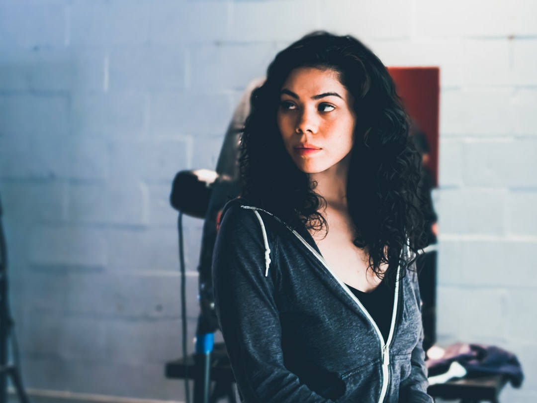 A Native American Woman in a hoodie and black top waits to film her part in a music video. 