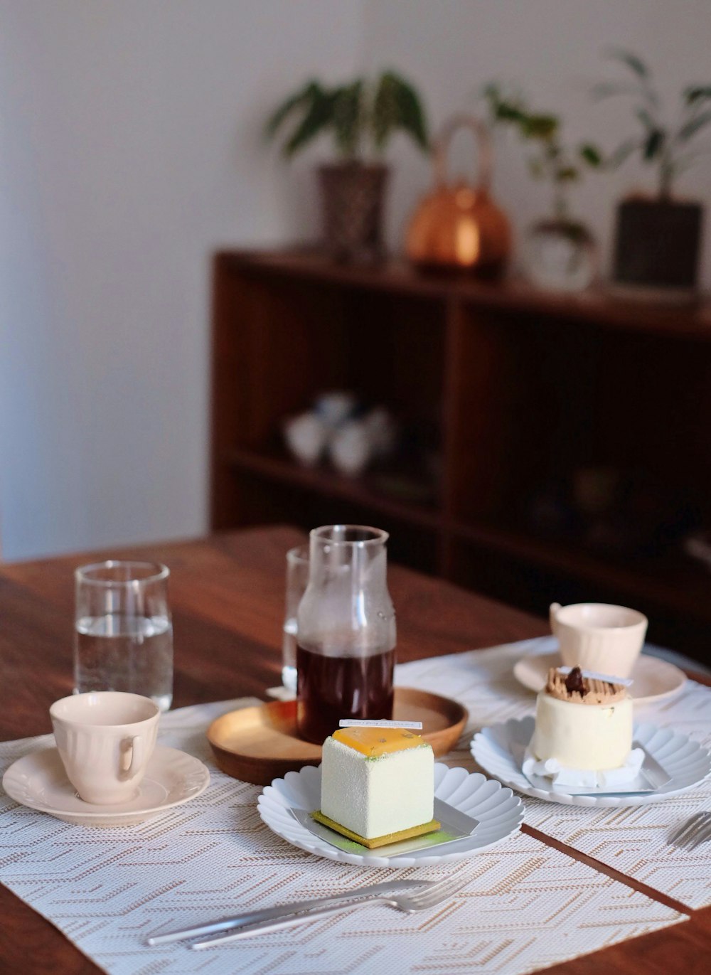 sliced cake on saucer beside mug and drinking glass