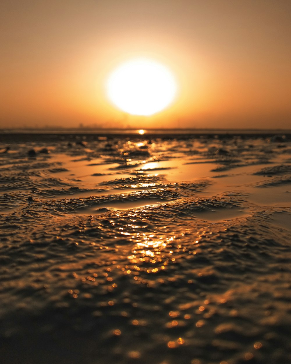 Plan d’eau sous le soleil avec ciel orangé