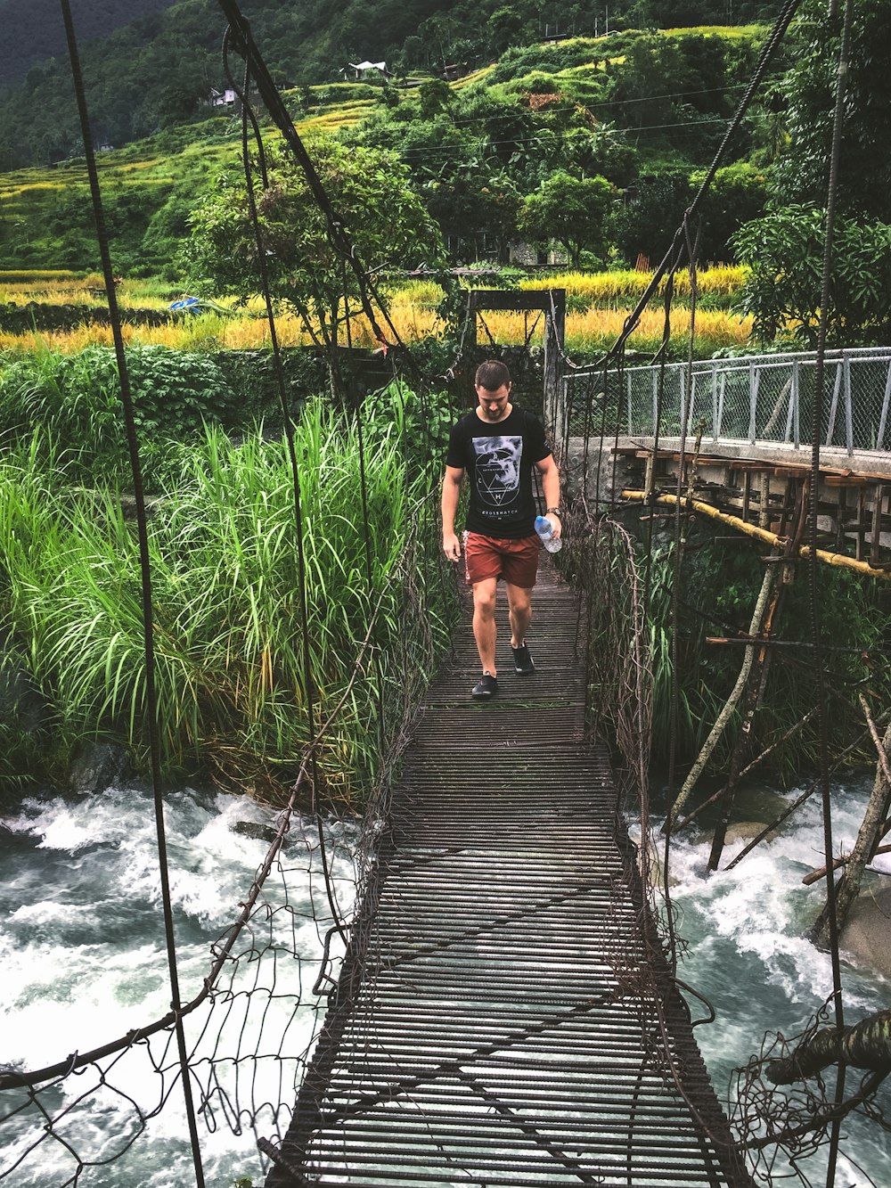 man walking on hanging bridge