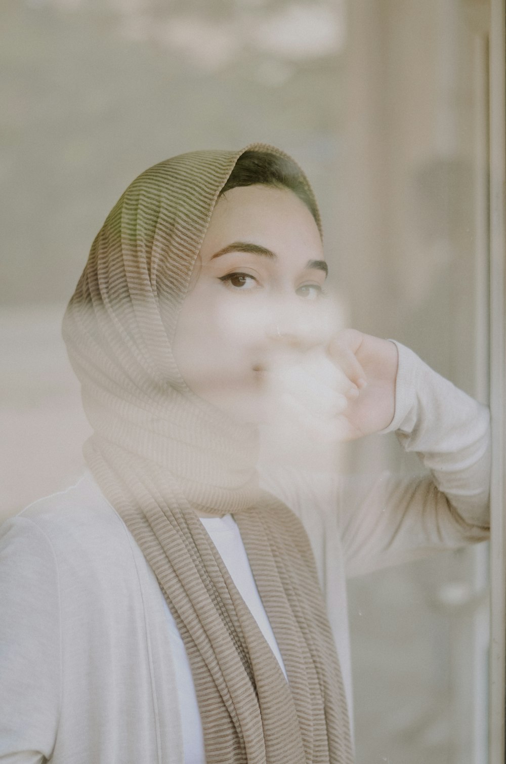 selective focus photography of woman leaning on glass wall