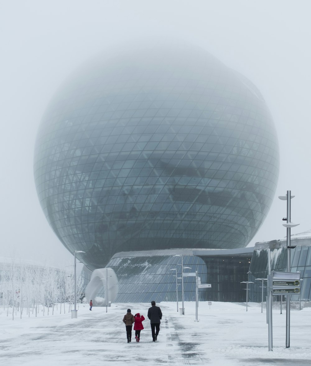 three person walking near tower