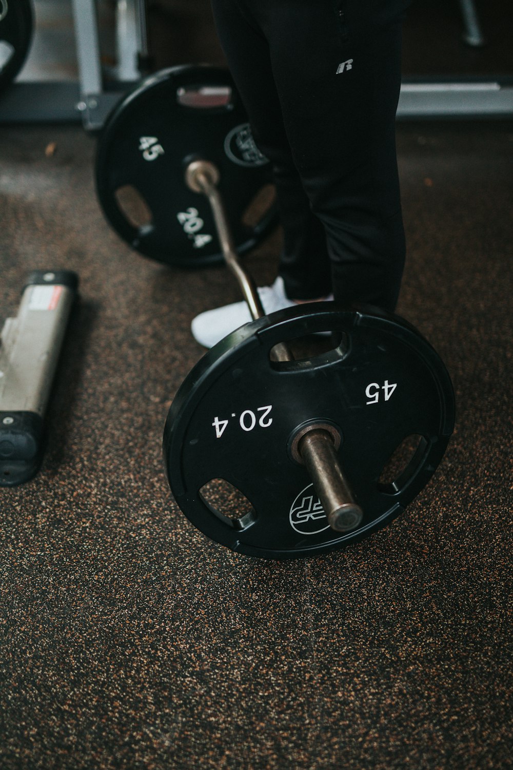 man standing beside barbell