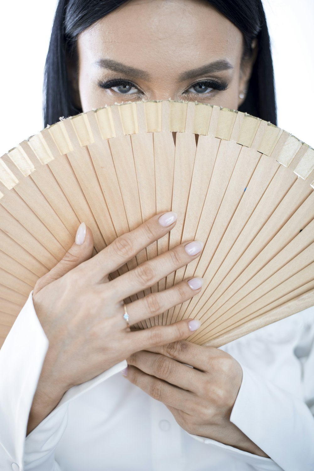 close-up photography of woman holding handfan