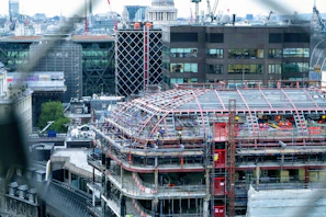 A sleek modern urban construction site in Guadalajara with cranes and workers.