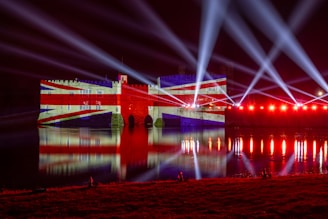 a red white and blue building some lights and water