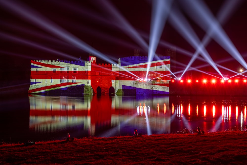 a red white and blue building some lights and water