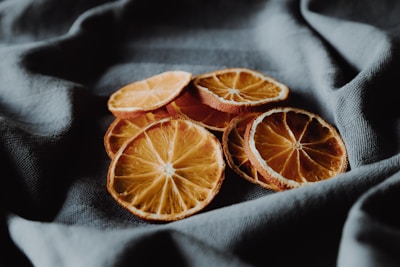 Close-up of vibrant dried orange slices arranged elegantly on a white marble surface.