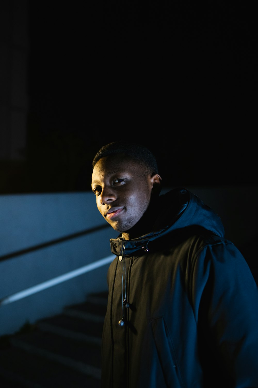 man standing in stairs wearing black zip-up hoodie jacket