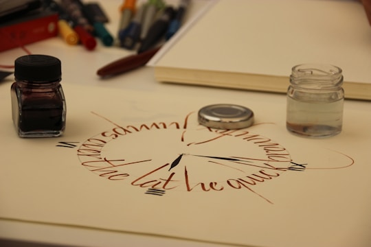 An artist's workspace featuring various lettering tools and colorful inks.