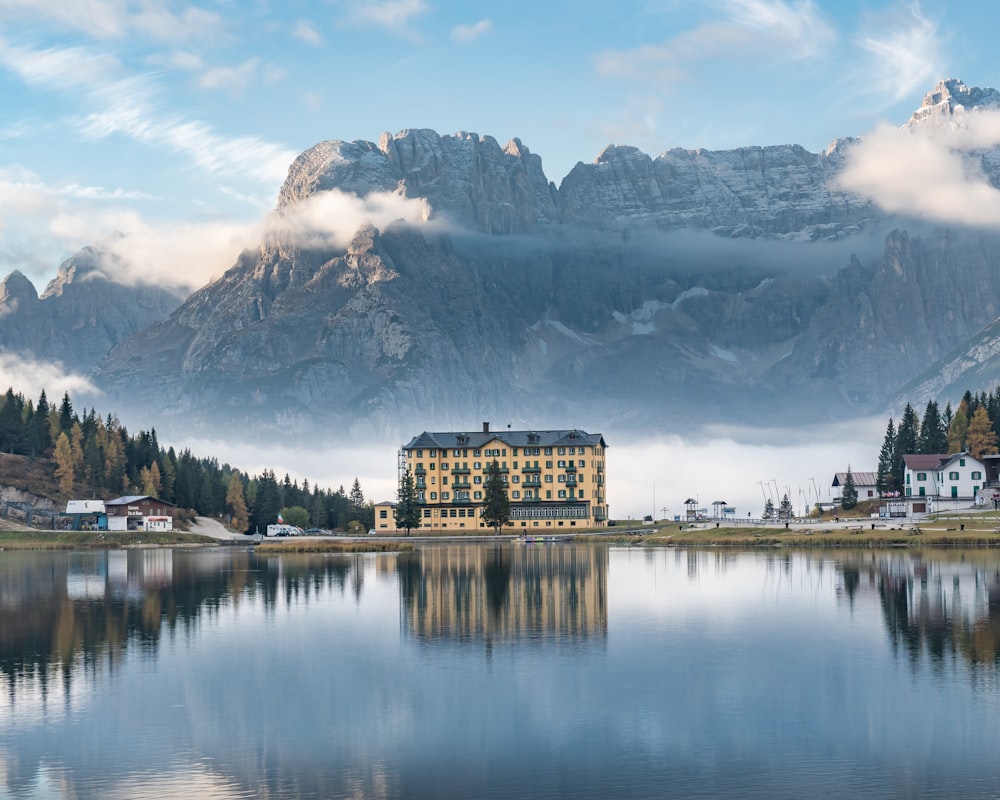 building near trees and body of water during day