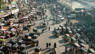 Bustling Delhi street with rickshaws and locals going about their day near India Gate.