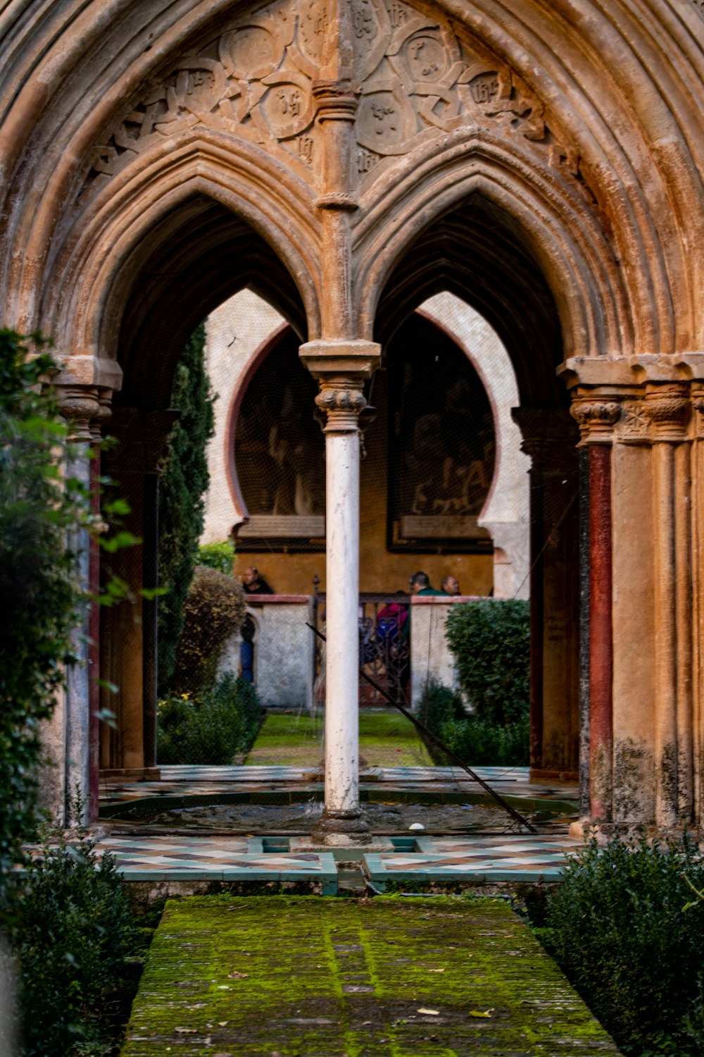 a large stone building with arches and a lawn