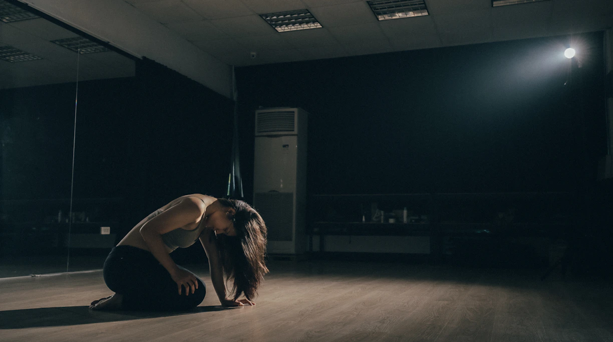 woman kneeling inside room near floor-type AC unit