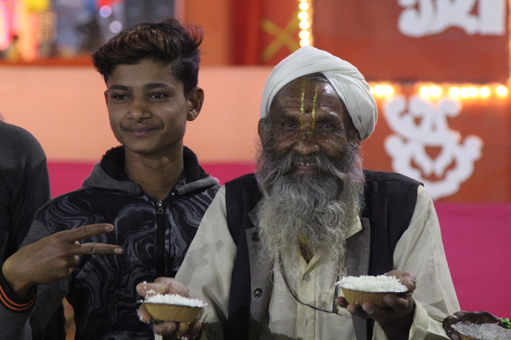 man smiling and holding foods beside man smiling