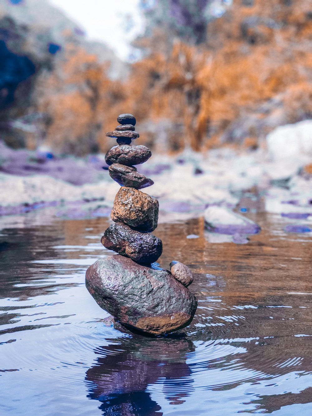 balanced stones on body of water