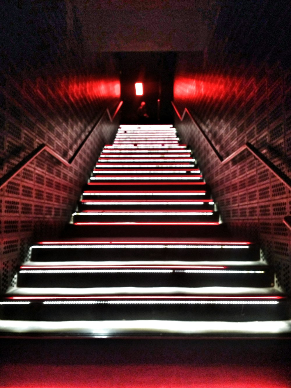 Photographie en contre-plongée d’un escalier étroit éclairé