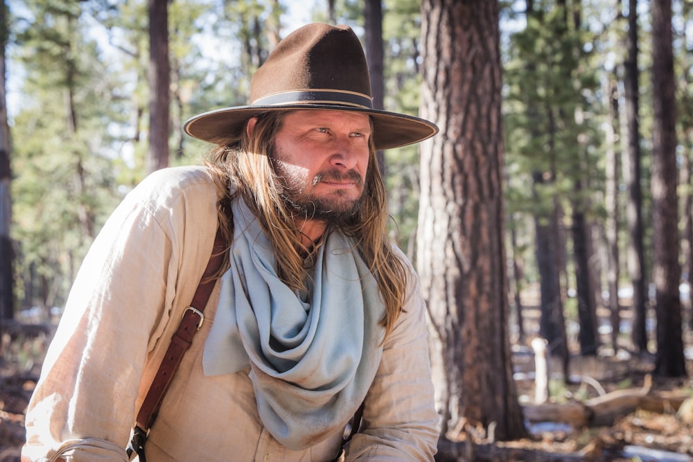 man wearing brown cowboy hat and gray scarf