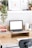 An elegant workspace featuring a minimalist desk, plants, and a bright window view.