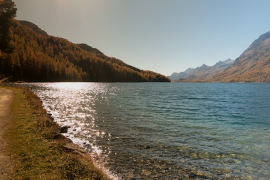 body of water and mountains during day in Engadin Switzerland