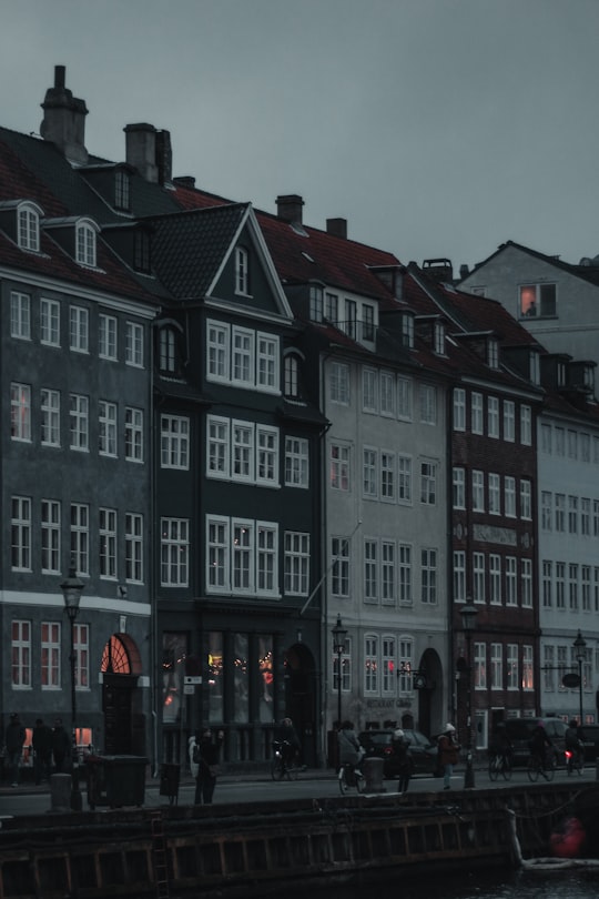 people walking by concrete buildings under gray skies in Ved Kajen Denmark