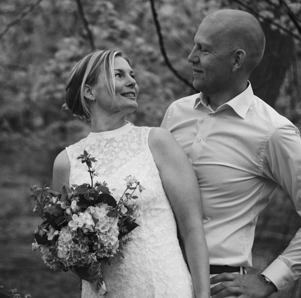 man and woman standing beside trees